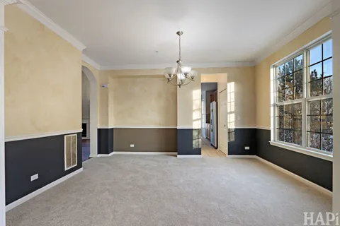 an empty room with windows and chandelier