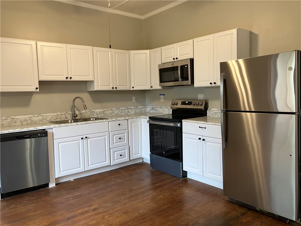 3 Wardlaw Street Pelzer, SC 29669 - Photo 4 of 6 Completely remodeled kitchen features new white cabinetry, new stainless steel appliances, and rich wood flooring.