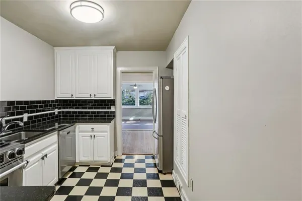 a kitchen with a refrigerator and white cabinets