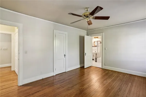 a view of a room with wooden floor and ceiling fan
