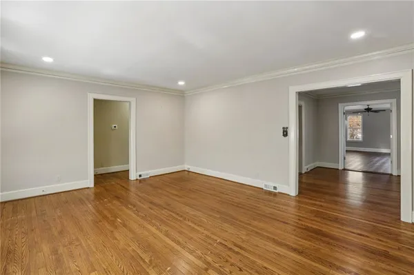 an empty room with wooden floor and mirror