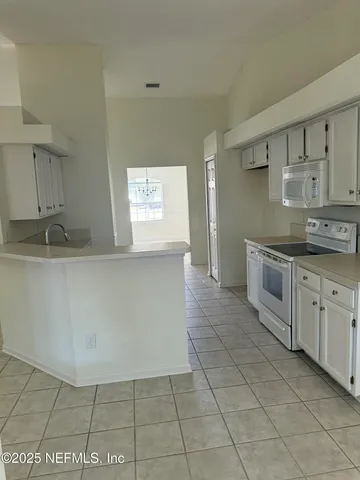 a kitchen with a sink a stove and cabinets