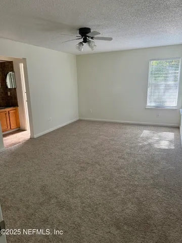 a view of a livingroom with a ceiling fan and window