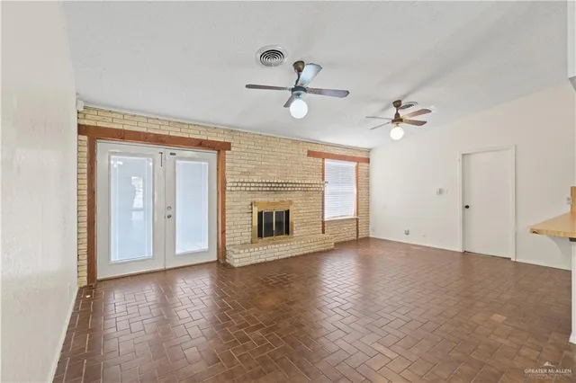 a view of an empty room with a fireplace and a window