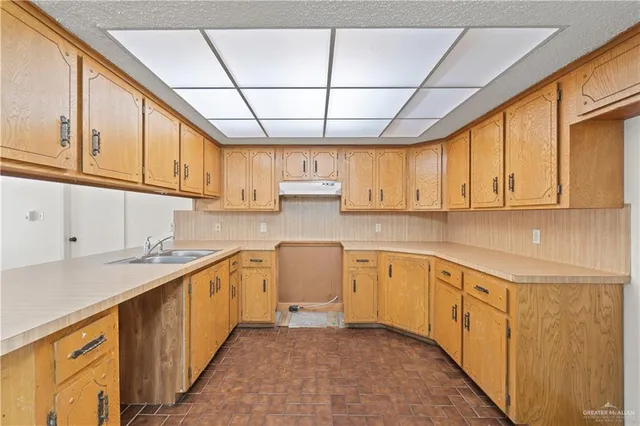 a kitchen with a sink window and cabinets