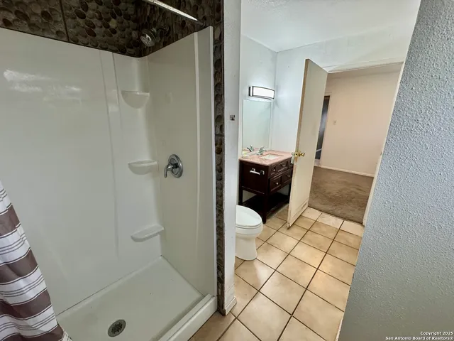 an empty room with a ceiling fan and carpet