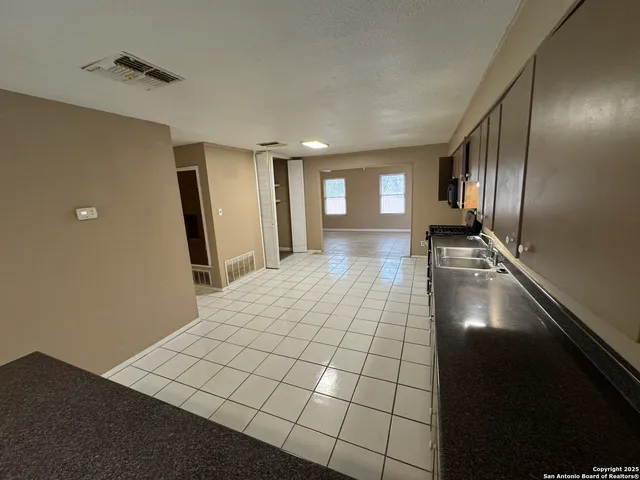 a view of a refrigerator in kitchen and windows