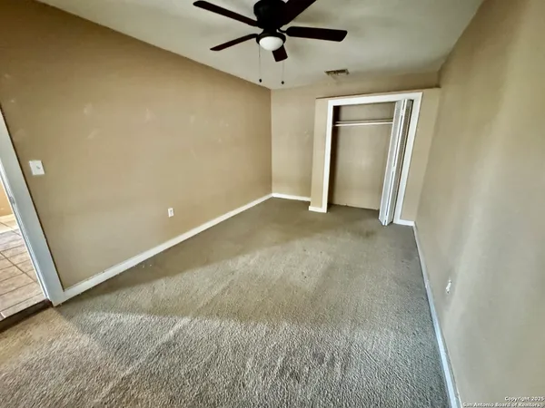 a view of a livingroom with a ceiling fan and window