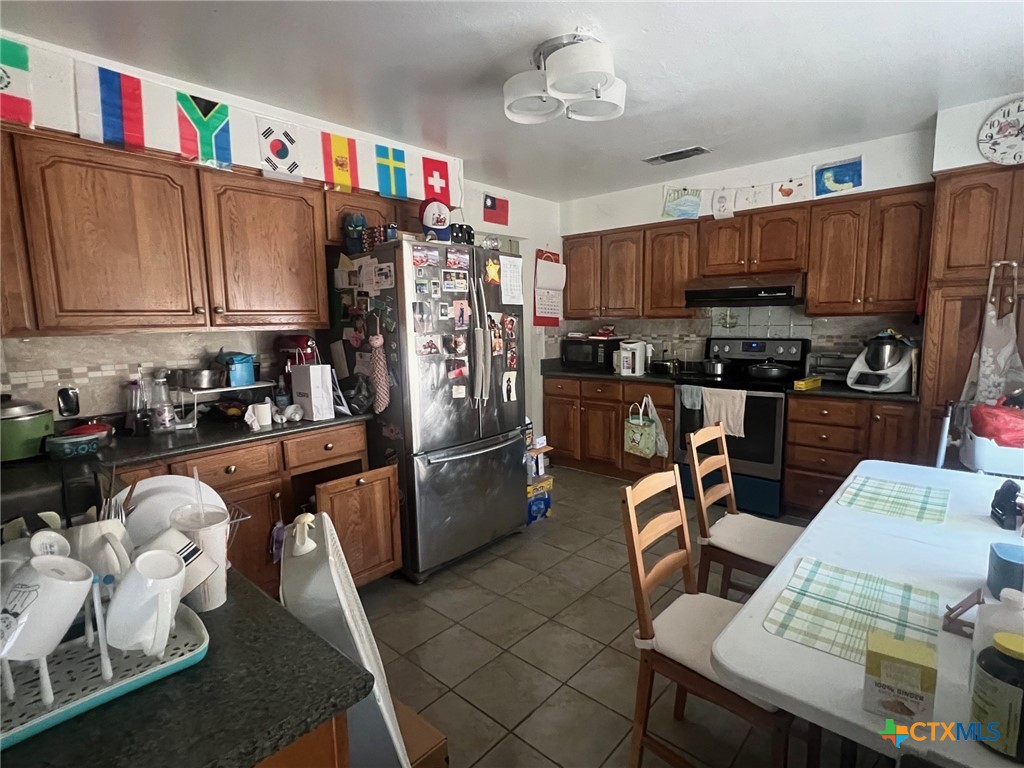 114 Chevy Chase Street Port Lavaca, TX 77979 - Photo 5 of 11 a kitchen with granite countertop a refrigerator and a stove top oven