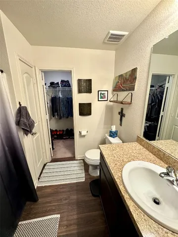 a bedroom with a bed and dresser with rug