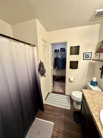 a en suite bathroom with a granite countertop sink and a mirror