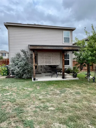 a backyard of a house with table and chairs
