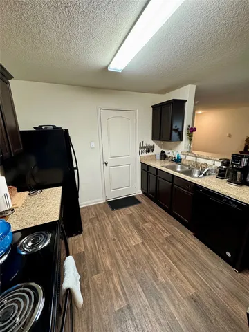 a kitchen with a sink cabinets and wooden floor