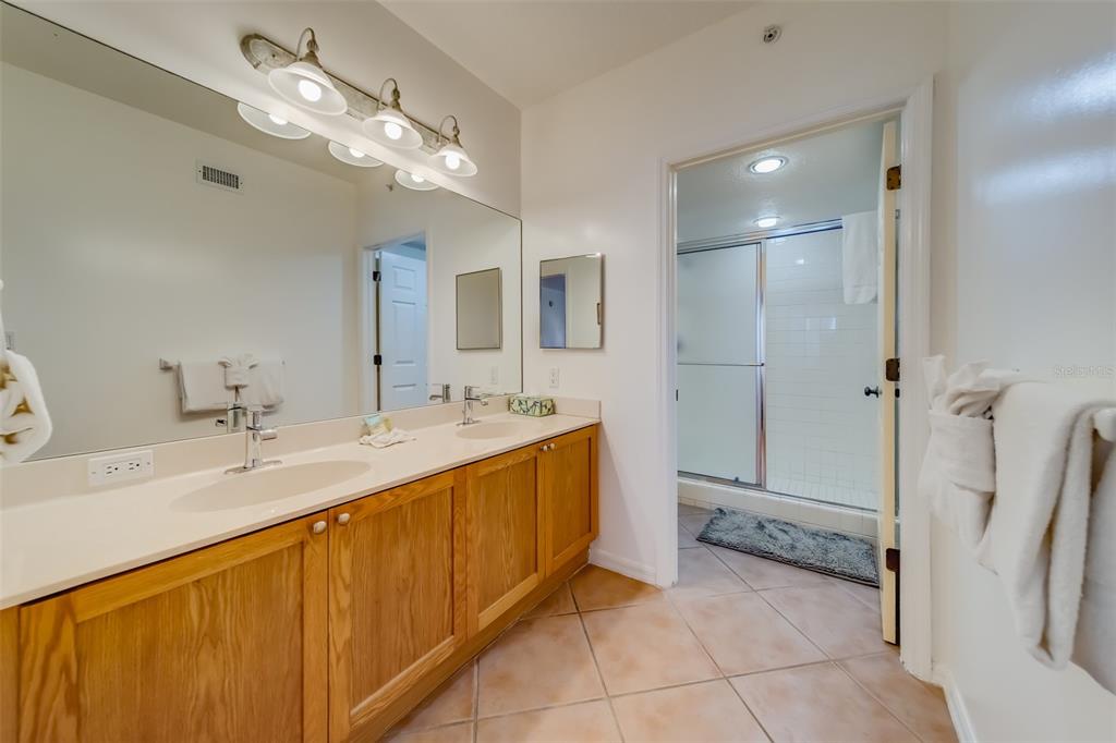 16550 Gulf Boulevard, Unit 643 North Redington Beach, FL 33708 - Photo 26 of 67 a spacious bathroom with a sink a large mirror and a shower