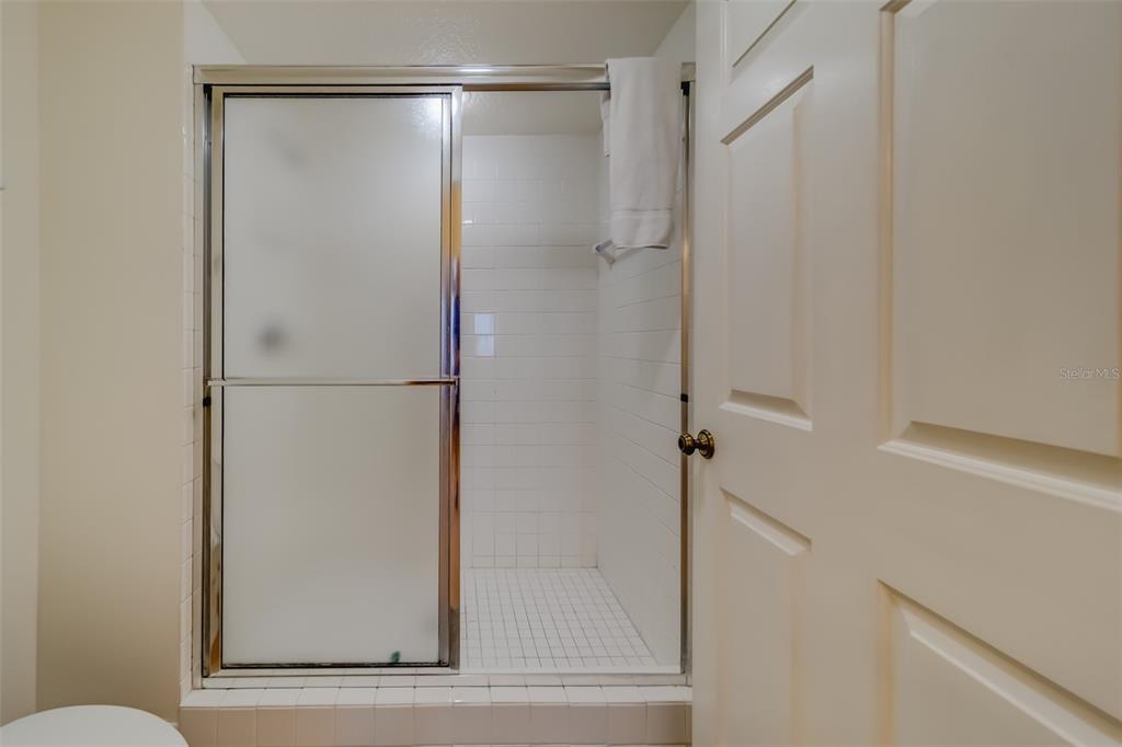16550 Gulf Boulevard, Unit 643 North Redington Beach, FL 33708 - Photo 27 of 67 a bathroom with a glass shower door