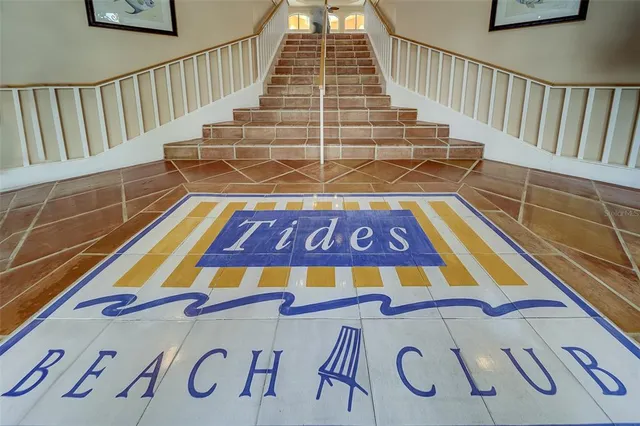a living room with furniture a flat screen tv and a refrigerator