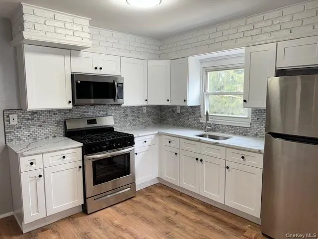 a kitchen with stainless steel appliances granite countertop a stove a microwave and a refrigerator