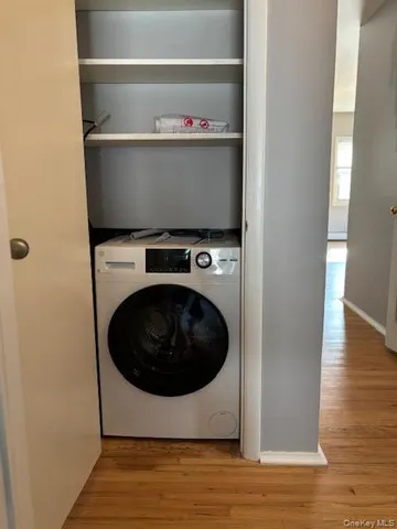 a utility room with wooden floor washer and dryer