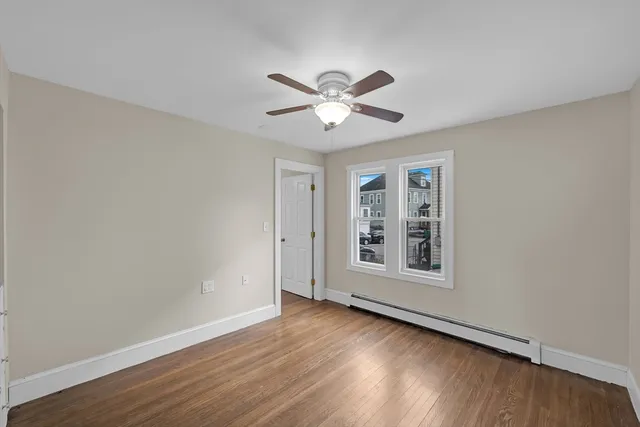 a view of a big room with wooden floor and windows