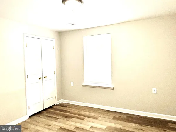 a view of a room with wooden floor and a window