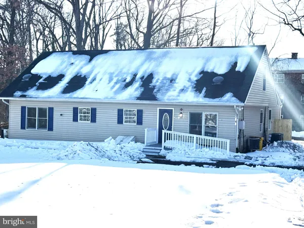 a front view of a house with a yard covered with snow