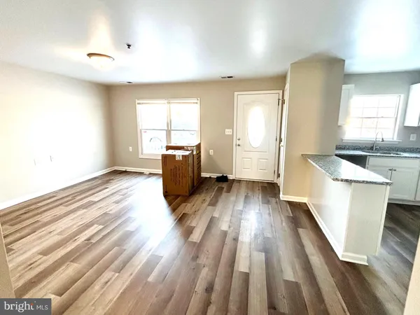 a view of a kitchen with wooden floor and electronic appliances