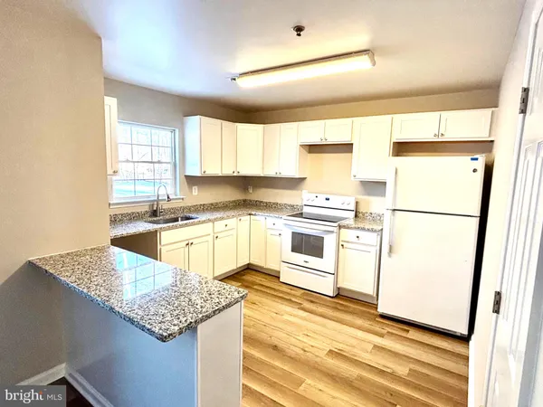 a kitchen with stainless steel appliances granite countertop a refrigerator sink stove and cabinets