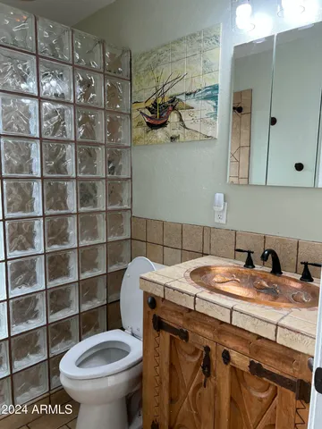 a bathroom with a sink a toilet and a mirror