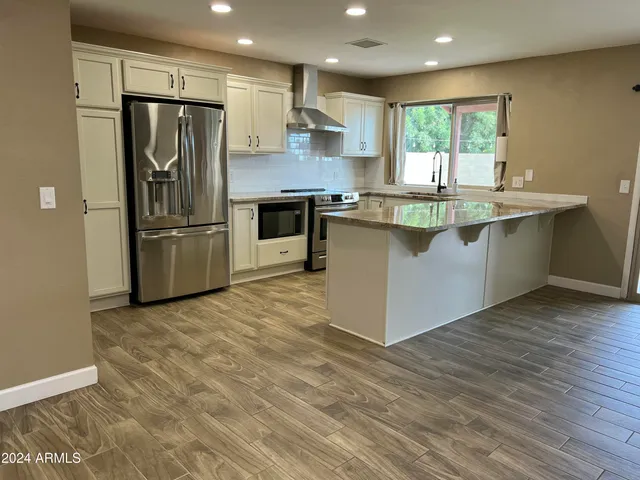 a kitchen with stainless steel appliances granite countertop a refrigerator and a sink