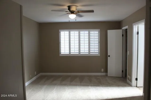 a view of room with a ceiling fan and a window