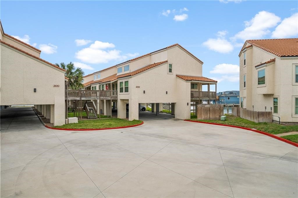 a view of a white house with a big yard and large tree