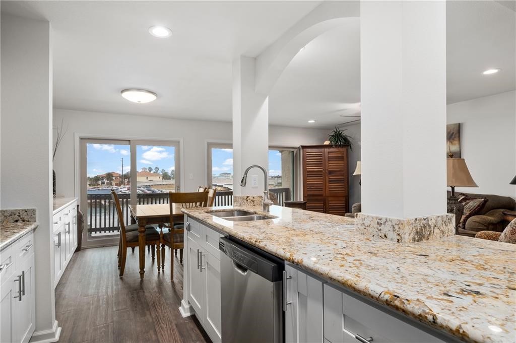 620 Fulton Beach Road, Unit 203 Rockport, TX 78382 - Photo 11 of 37 a kitchen with granite countertop a stove a sink a dining table and chairs