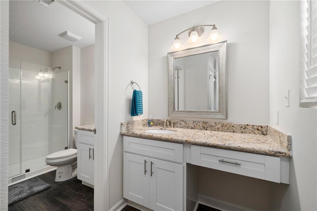 620 Fulton Beach Road, Unit 203 Rockport, TX 78382 - Photo 22 of 37 a bathroom with a granite countertop sink a toilet and a mirror