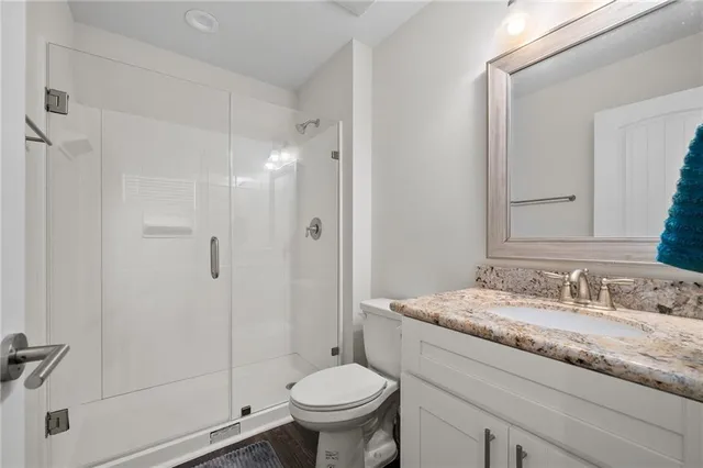 a bathroom with a granite countertop sink toilet and shower