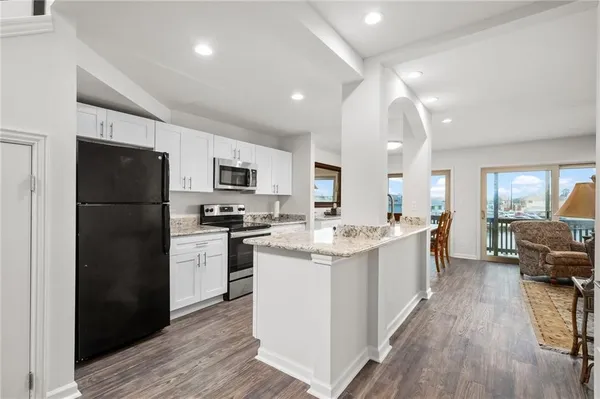 a kitchen with stainless steel appliances granite countertop a refrigerator stove and sink