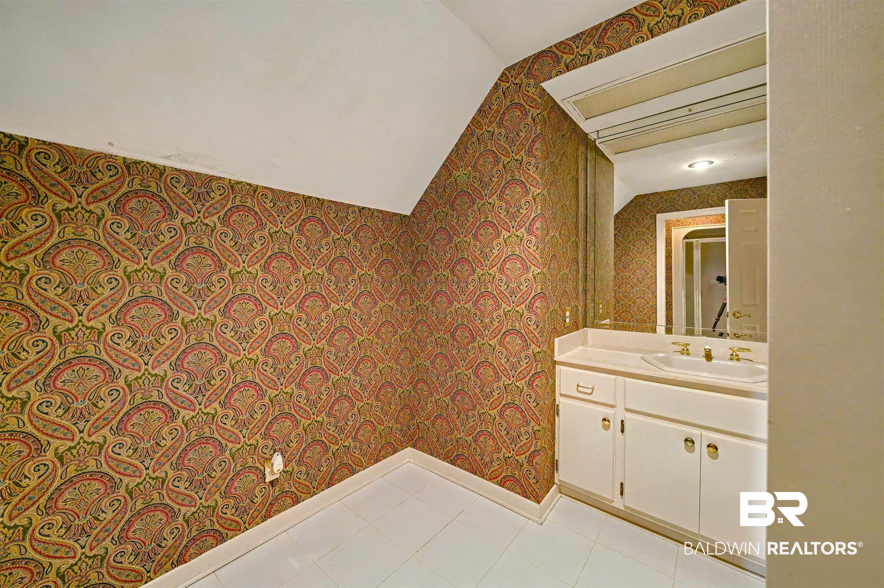 15810 County Road 73 Foley, AL 36535 - Photo 37 of 56 Bathroom featuring wallpapered walls, vanity, vaulted ceiling, and light tile patterned floors