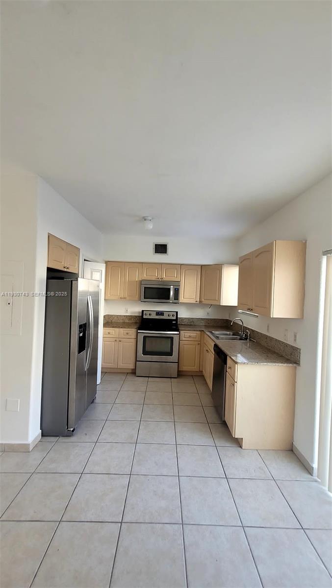 a kitchen with granite countertop a refrigerator and a stove