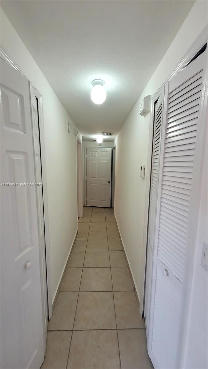 7241 Northwest 174th Terrace, Unit 103 Hialeah, FL 33015 - Photo 14 of 19 a view of hallway with a large window and a refrigerator