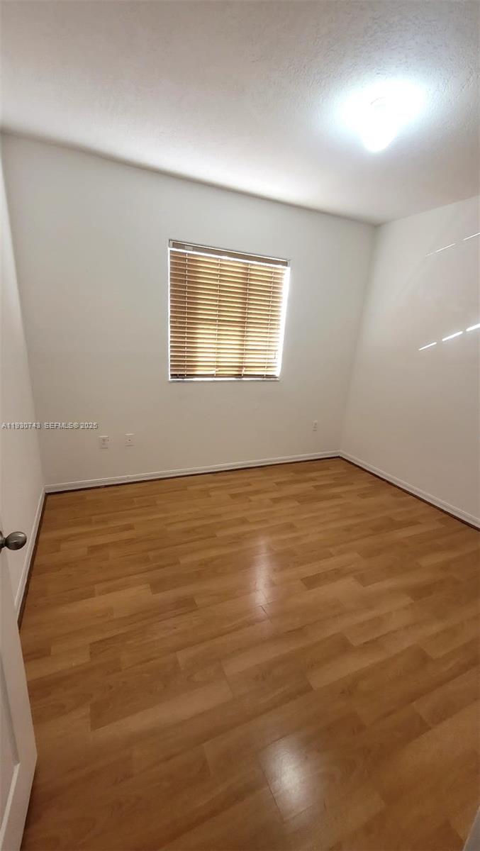 7241 Northwest 174th Terrace, Unit 103 Hialeah, FL 33015 - Photo 3 of 19 wooden floor in an empty room