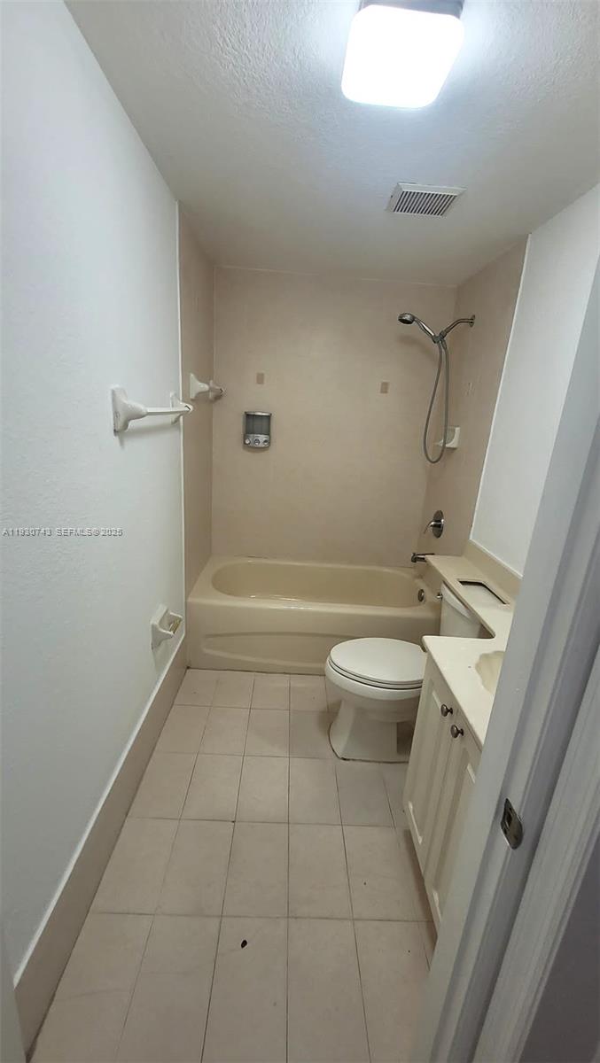 7241 Northwest 174th Terrace, Unit 103 Hialeah, FL 33015 - Photo 7 of 19 a bathroom with a granite countertop toilet a sink and shower
