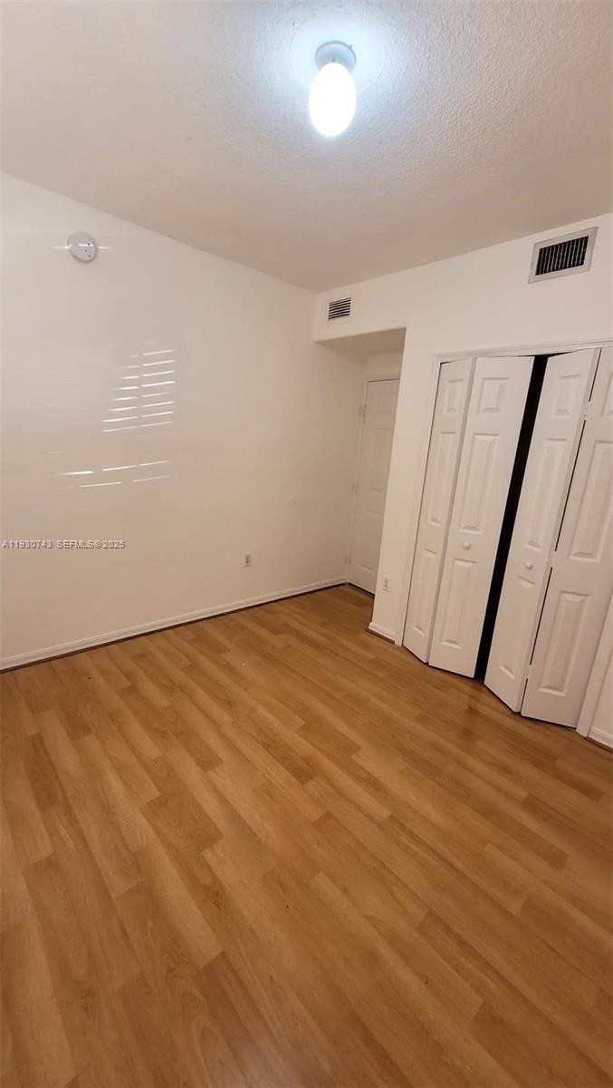7241 Northwest 174th Terrace, Unit 103 Hialeah, FL 33015 - Photo 10 of 19 wooden floor in an empty room