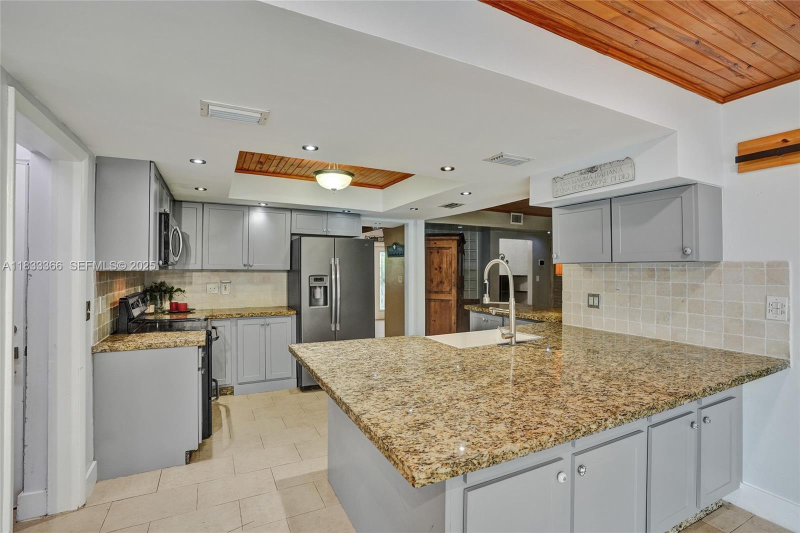 5840 Southwest 19th Street Plantation, FL 33317 - Photo 14 of 66 a kitchen with kitchen island sink stove and refrigerator