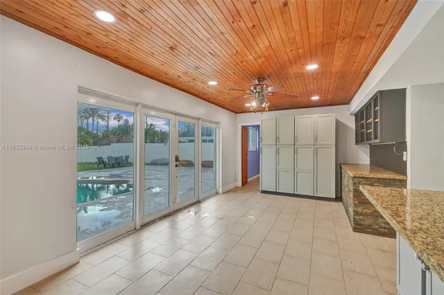 a view of a hallway with wooden floor and a living room
