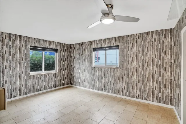 an empty room with a window and a fan