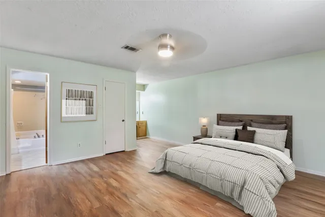 a bedroom with a large bed and a chandelier