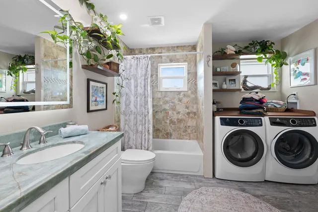 a bathroom with a granite countertop sink a mirror and shower