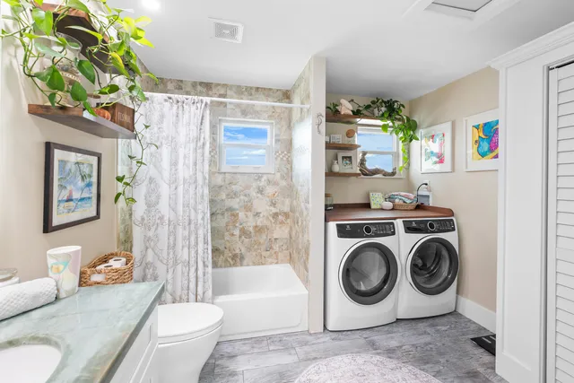 a utility room with sink dryer and washer