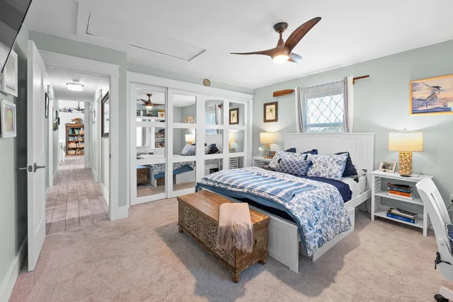 a spacious bedroom with a bed a table and painting