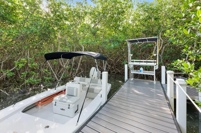 a balcony with wooden floor table and chairs