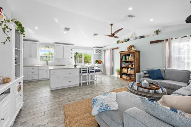 a living room with furniture and view of kitchen